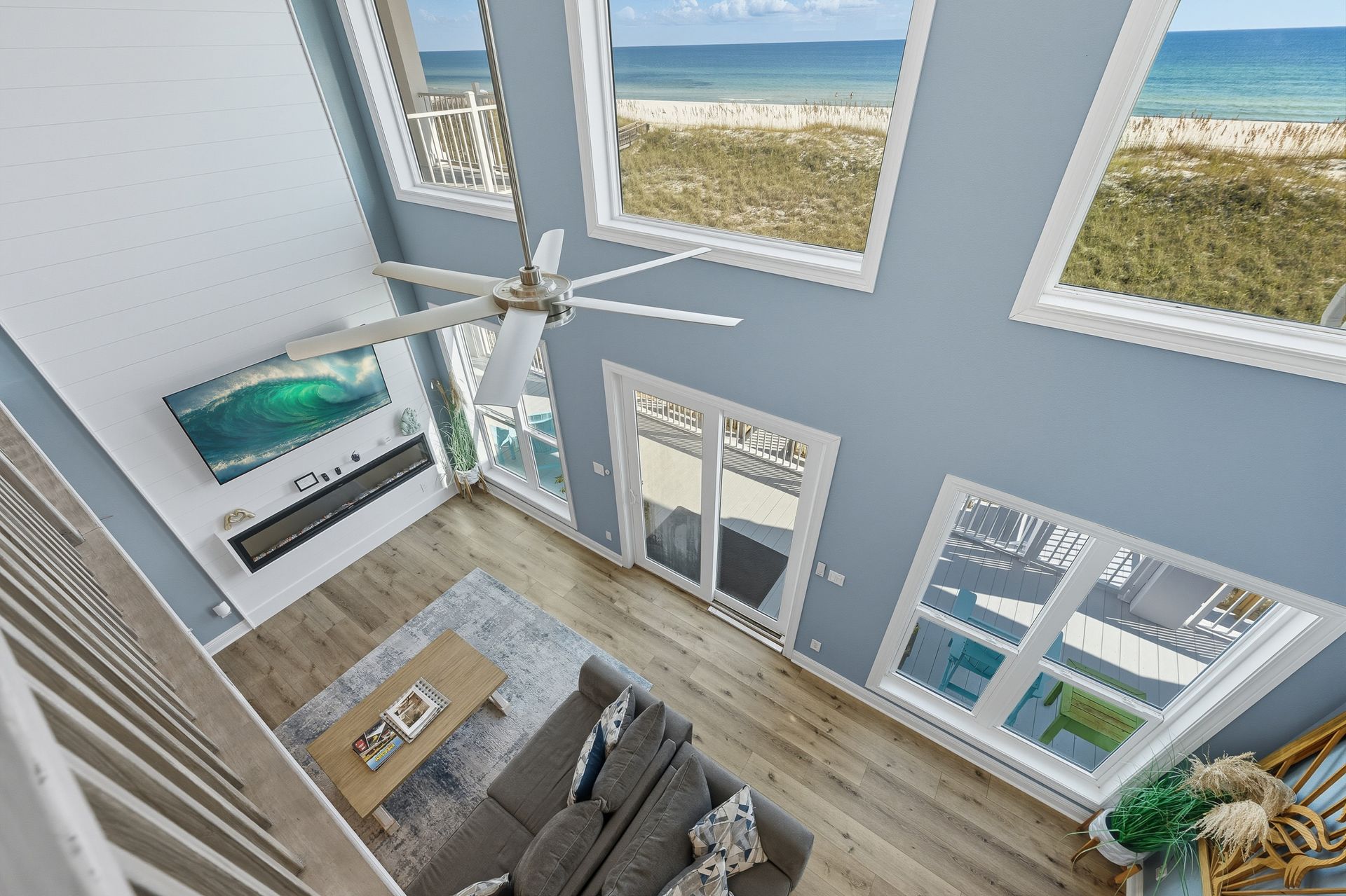 High-angle shot of a coastal living room with ocean view through large windows.
