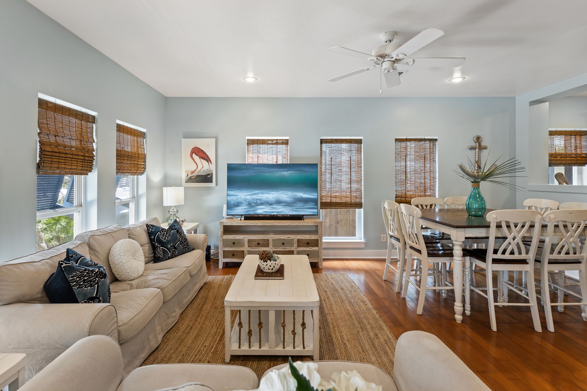Living room with blue walls, beige furniture, a TV, and dining table.