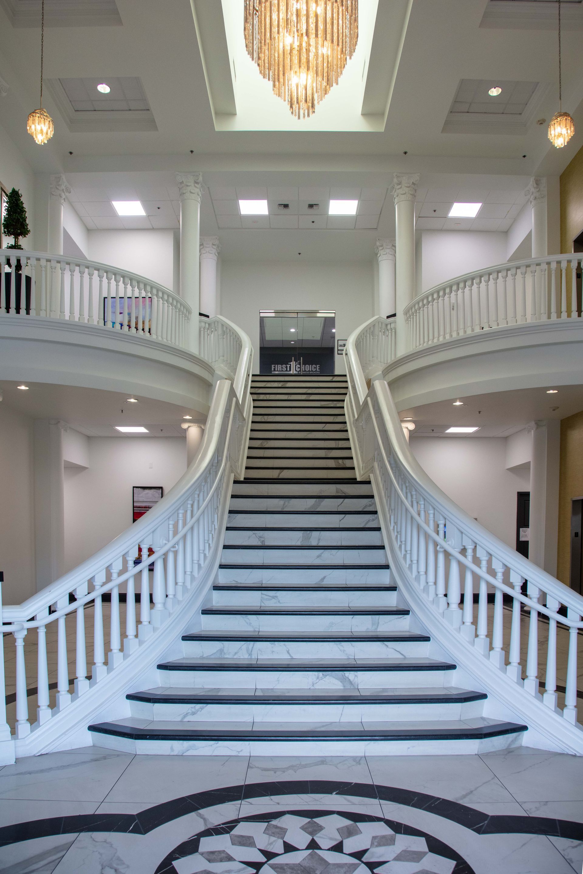 A large staircase in a building with a chandelier hanging from the ceiling.