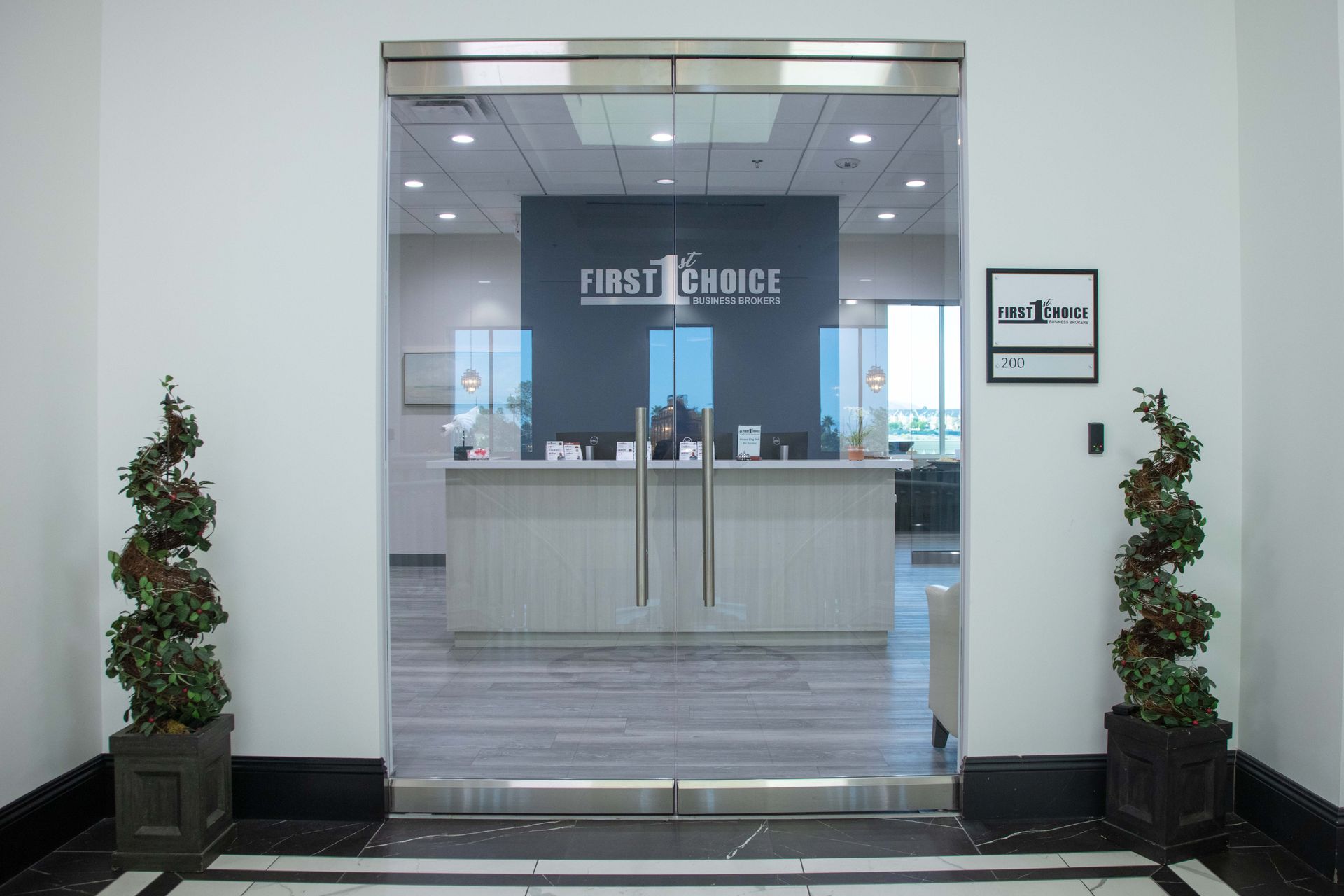 A lobby with a glass door leading to a reception desk.