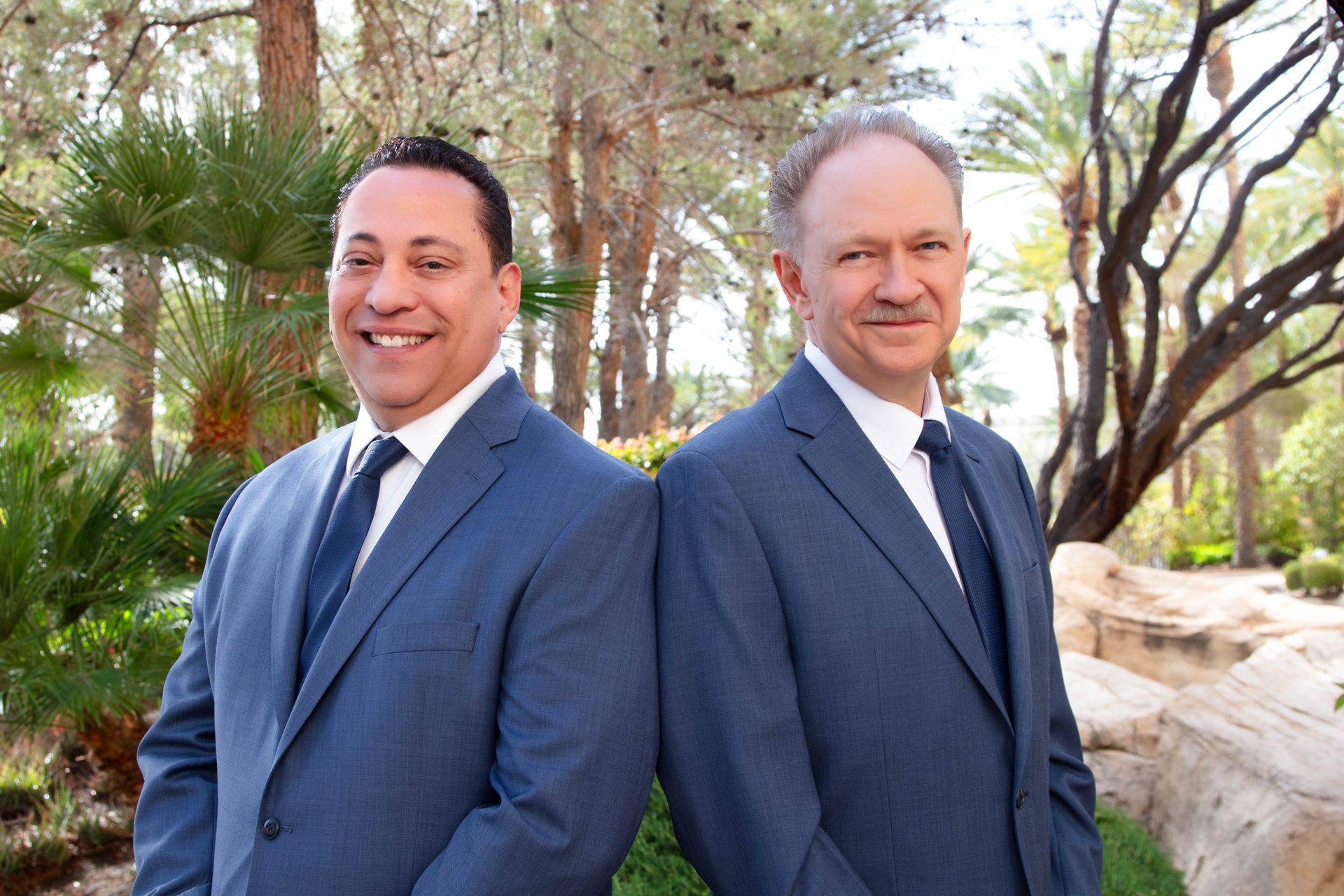 Two men in suits and ties are posing for a picture