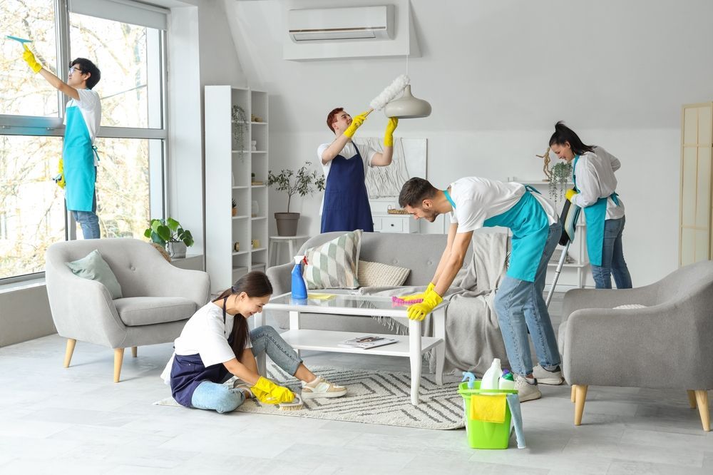 A group of people are cleaning a living room.