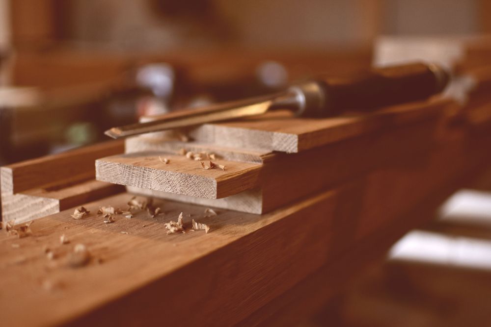 Chisel resting on wooden blocks with wood shavings; carpentry setting, close up.