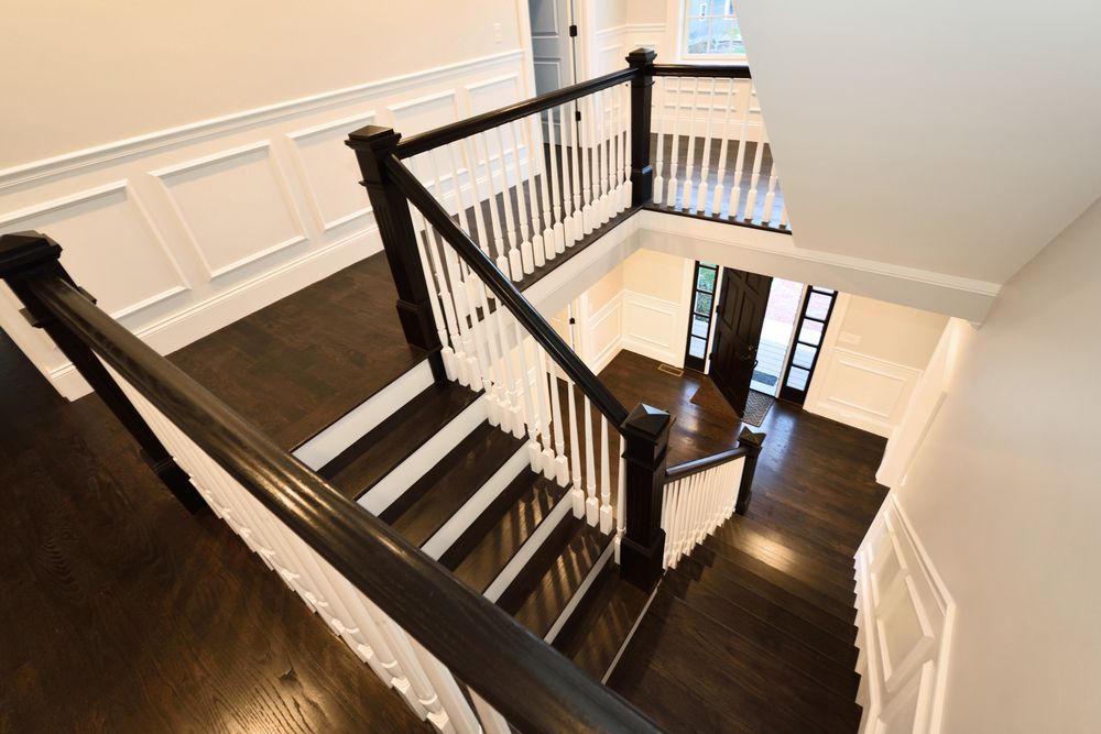 Dark wooden staircase with white railing, viewed from above, in a home.