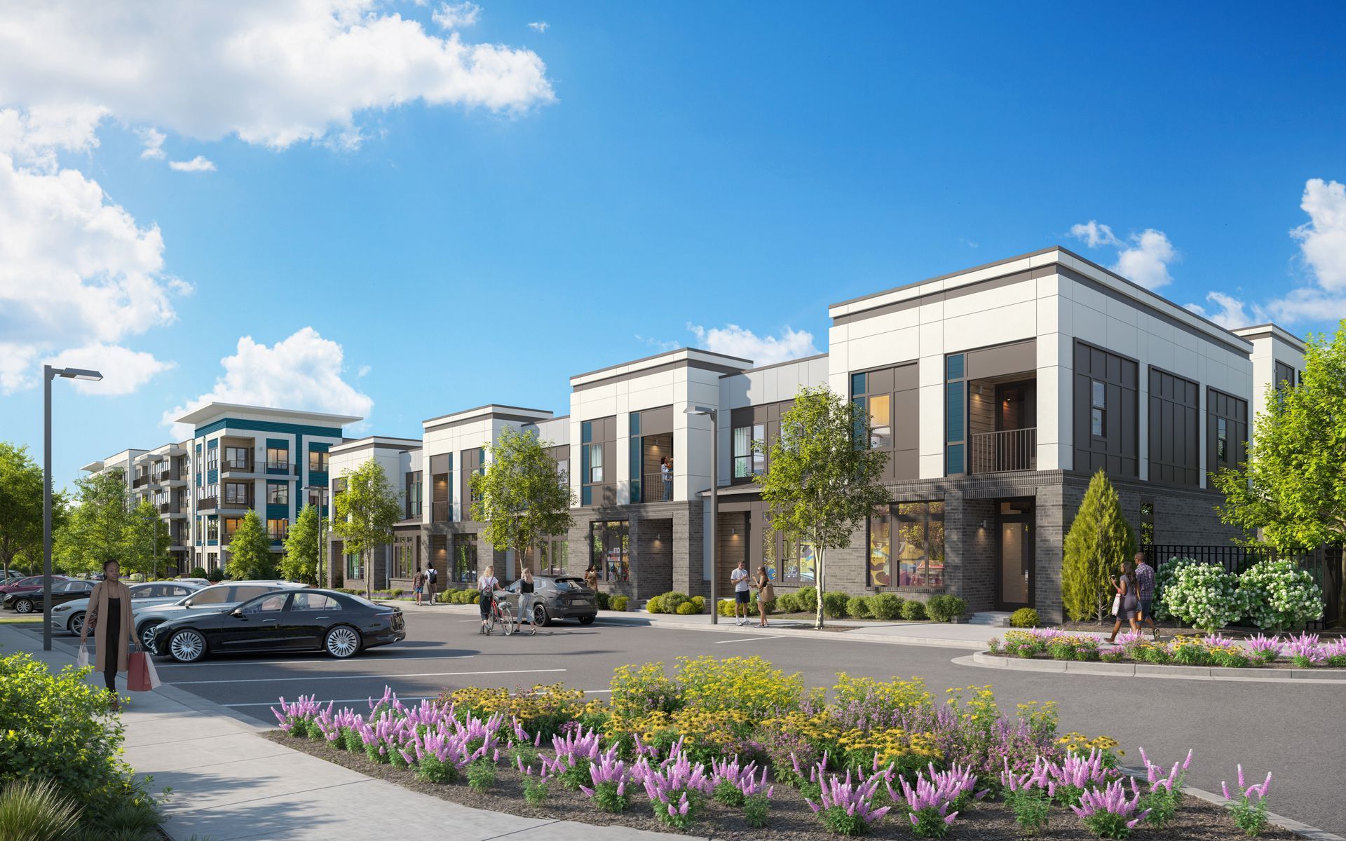 Modern apartment complex with parked cars, trees, and purple flowers under a blue sky at Vela Park apartments in East Lake, Atlanta, GA.