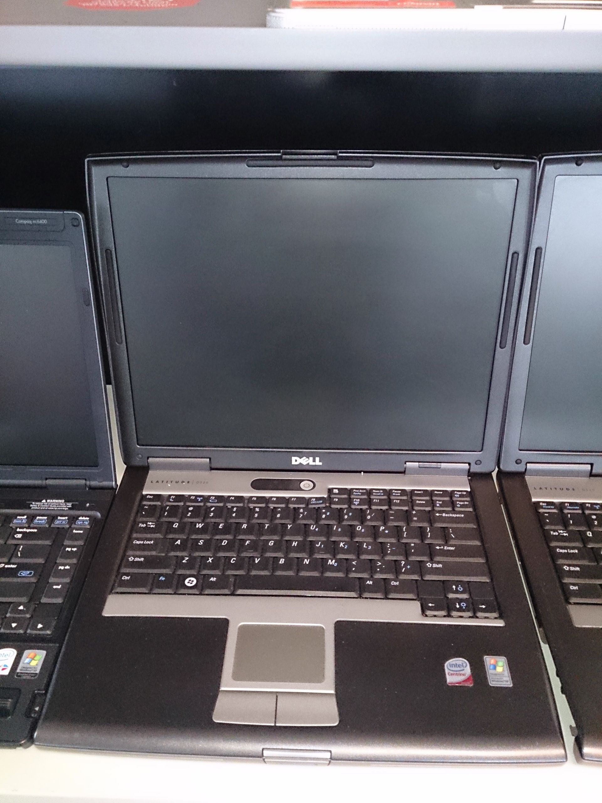 Three Dell laptops lined up with visible keyboards and screens.