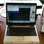 Laptop open on a desk, displaying a software interface. Silver and black.