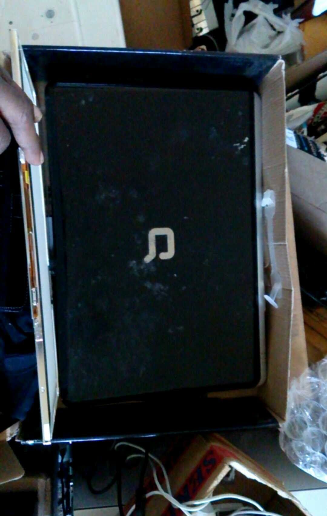 Black Compaq laptop in its box, viewed from above.