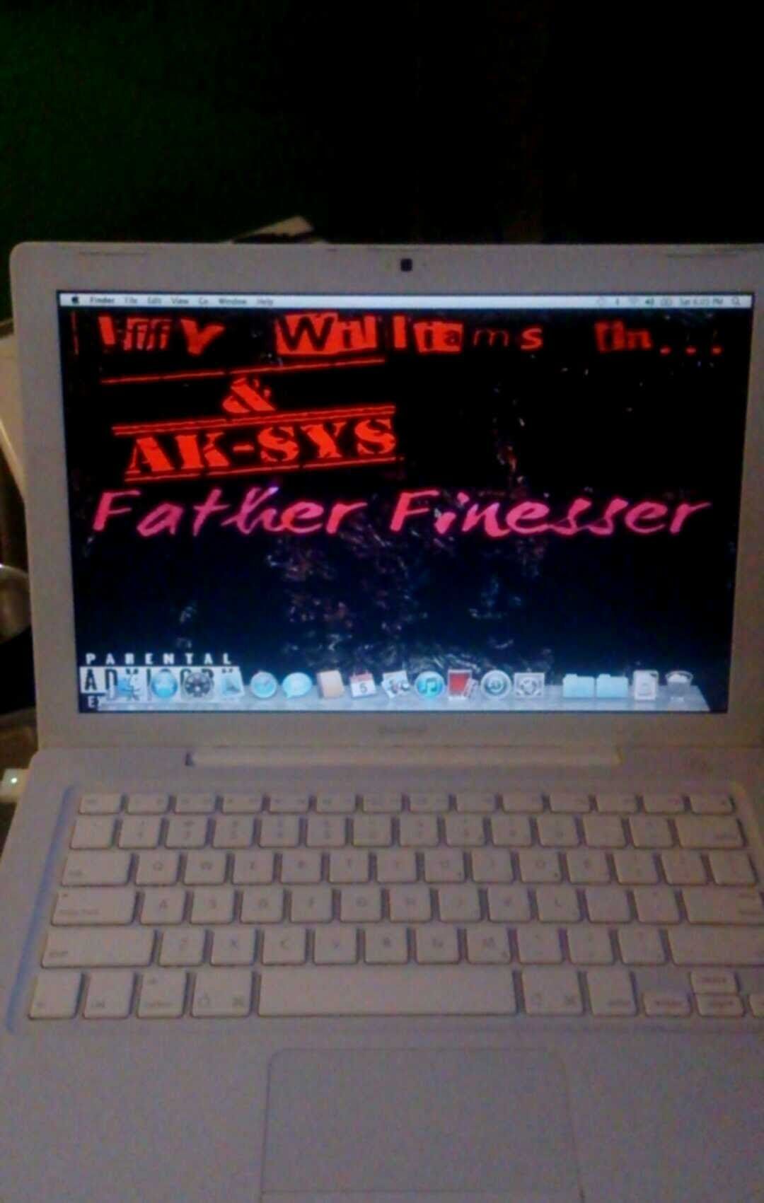 White laptop with screen displaying red text on a black background: 