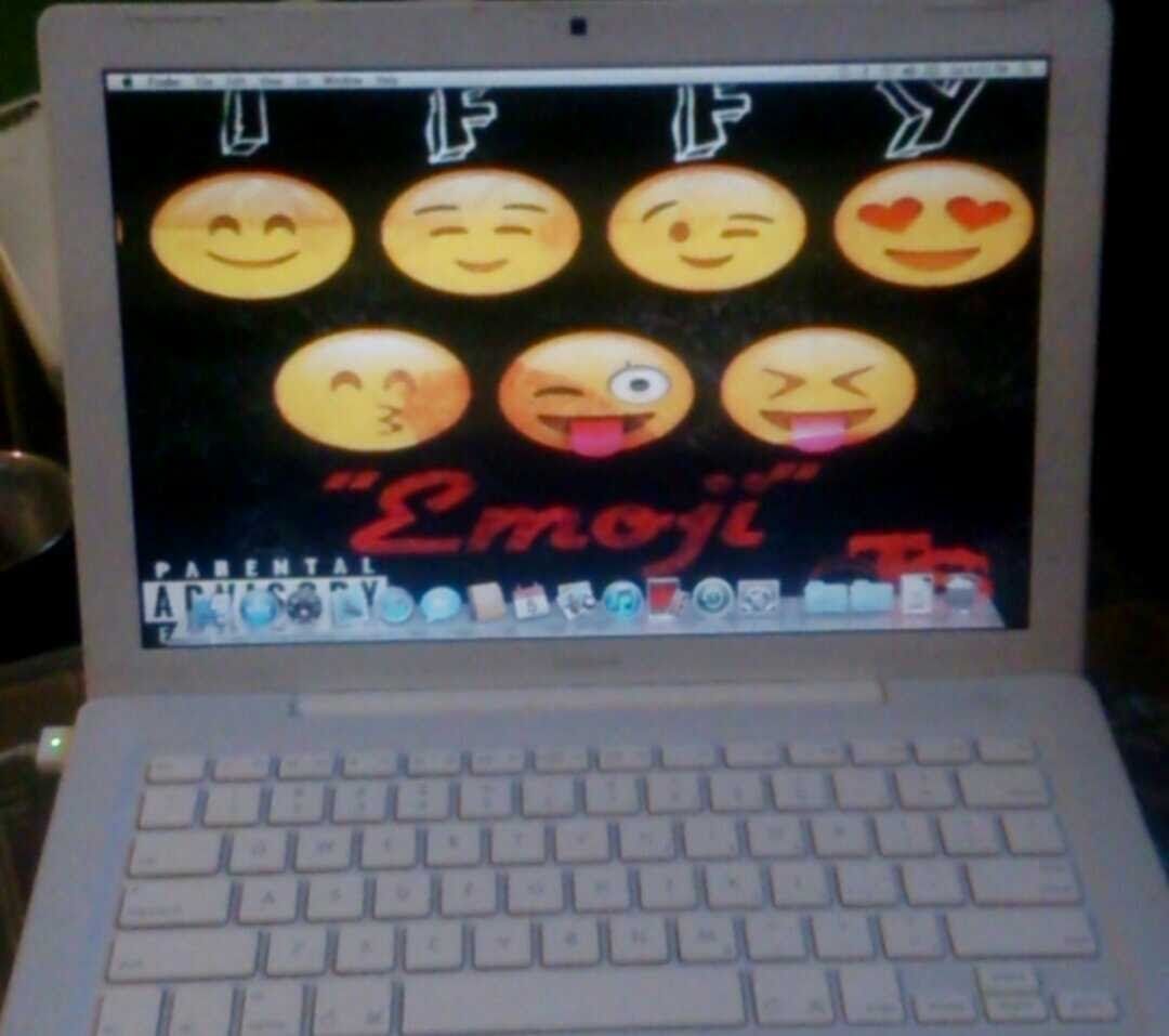 White laptop displaying a desktop with emoji faces and the word 