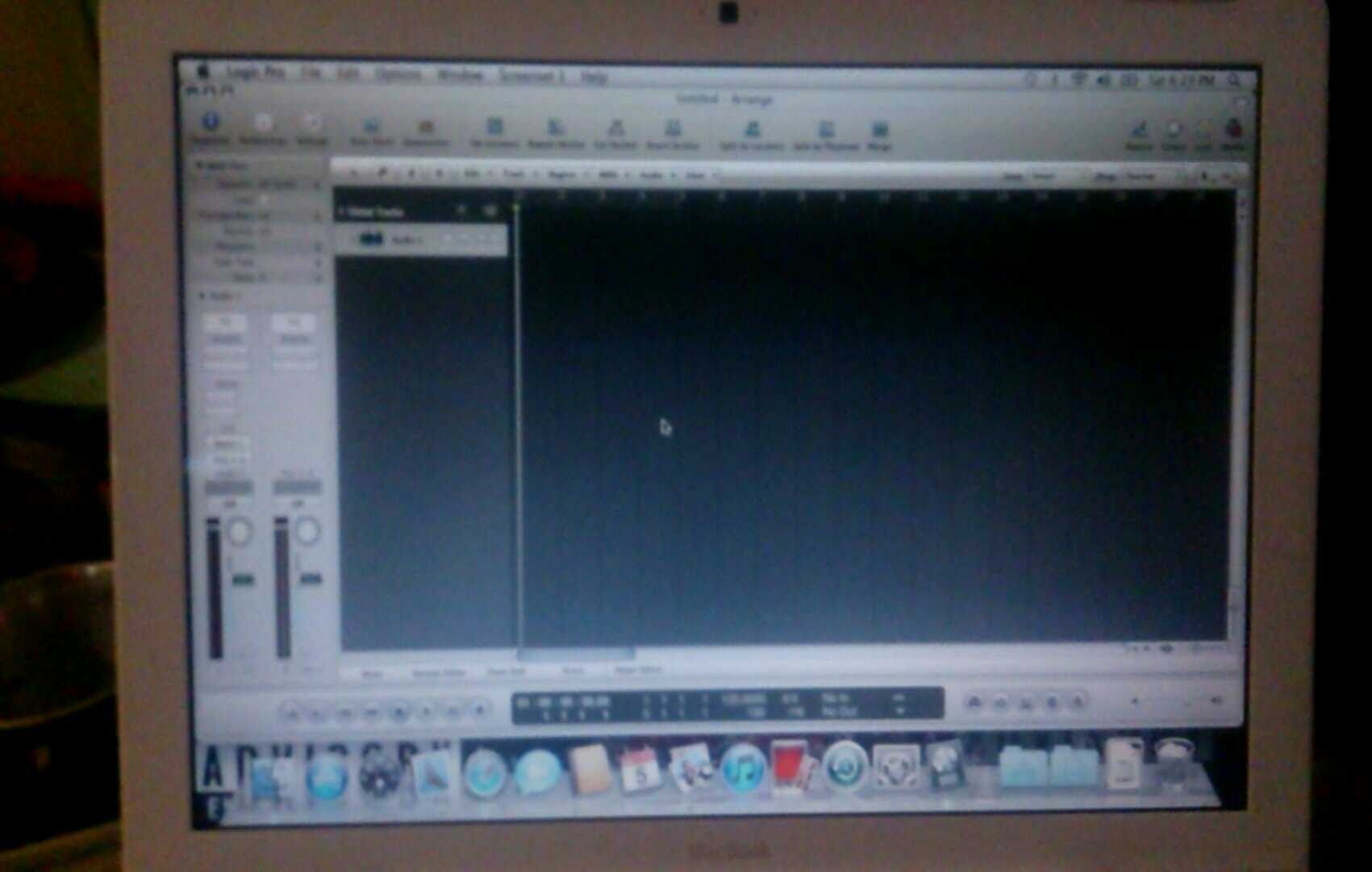 Laptop showing music production software interface; black and white.