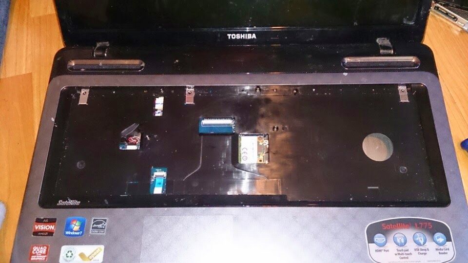 Laptop with keyboard removed, revealing internal components and mounting points.