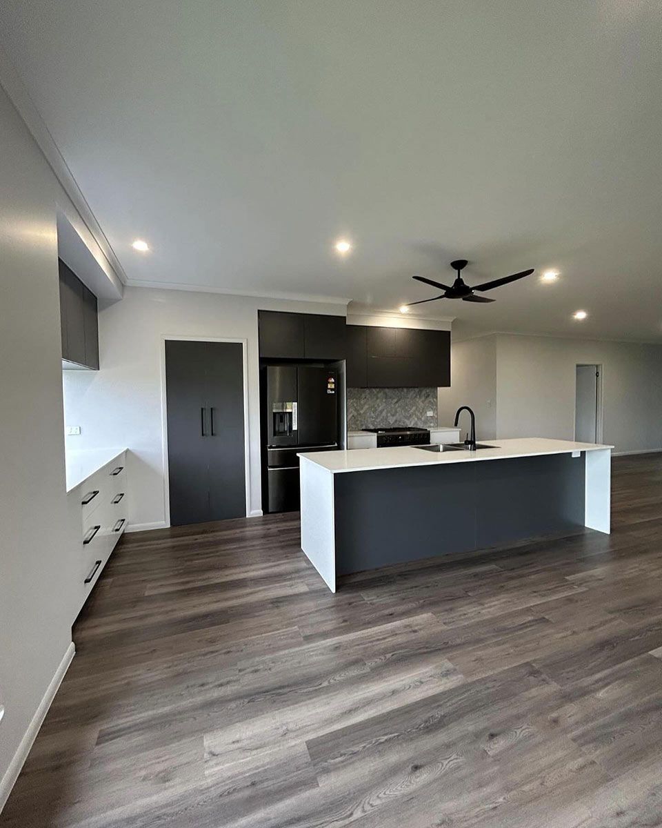 A Kitchen With A Large Island And A Ceiling Fan — Keilbach Kitchens In Garradunga, QLD