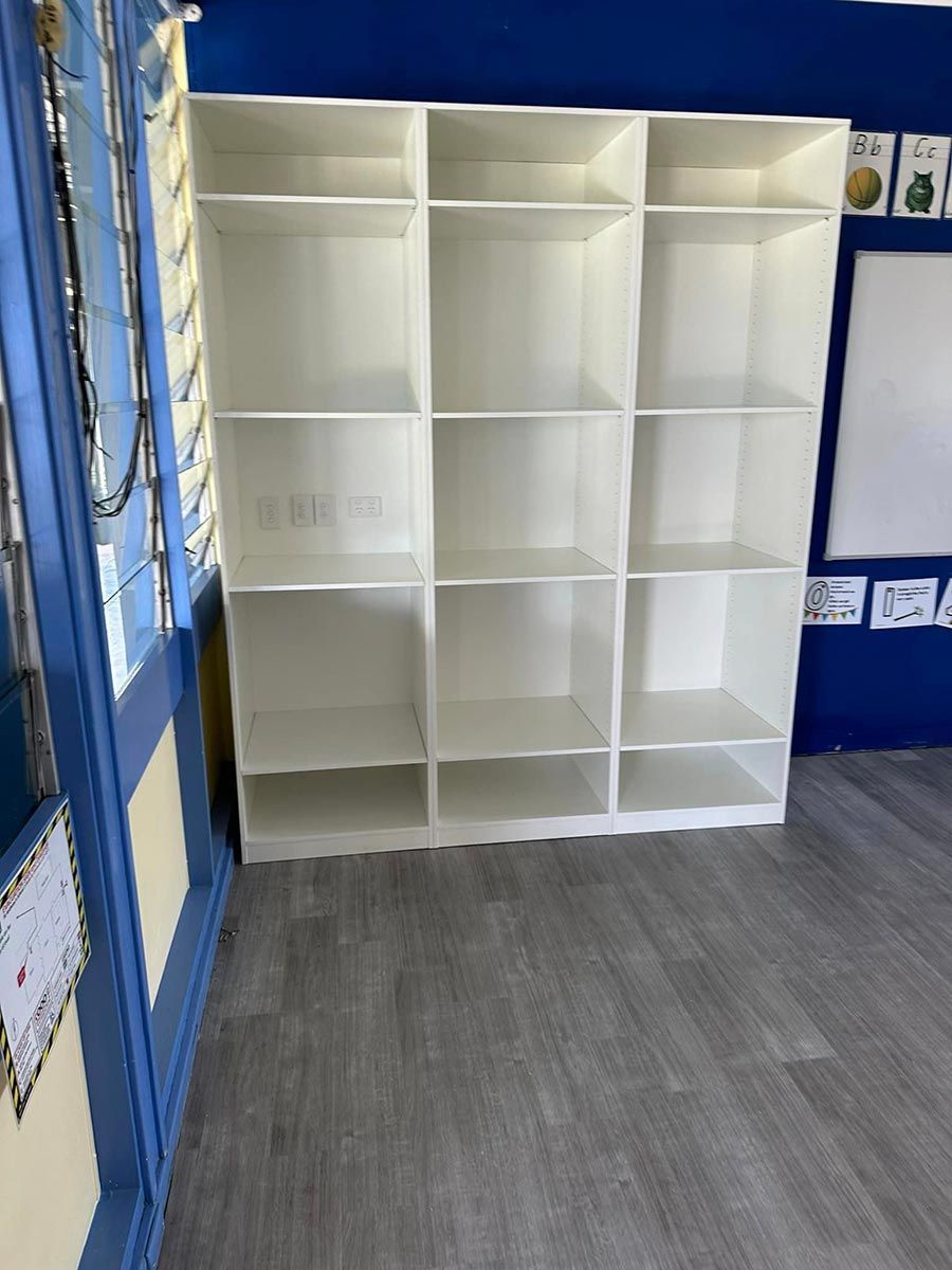 A Row Of White Shelves In A Room With A Blue Wall — Keilbach Kitchens In Garradunga, QLD
