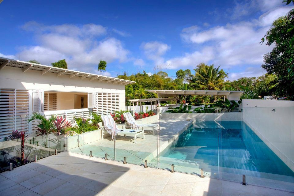 A White House With A Large Swimming Pool In Front Of It — Keilbach Kitchens In Tully, QLD