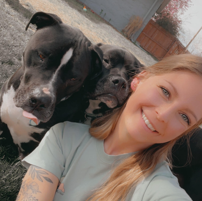 A woman is taking a selfie with two dogs.