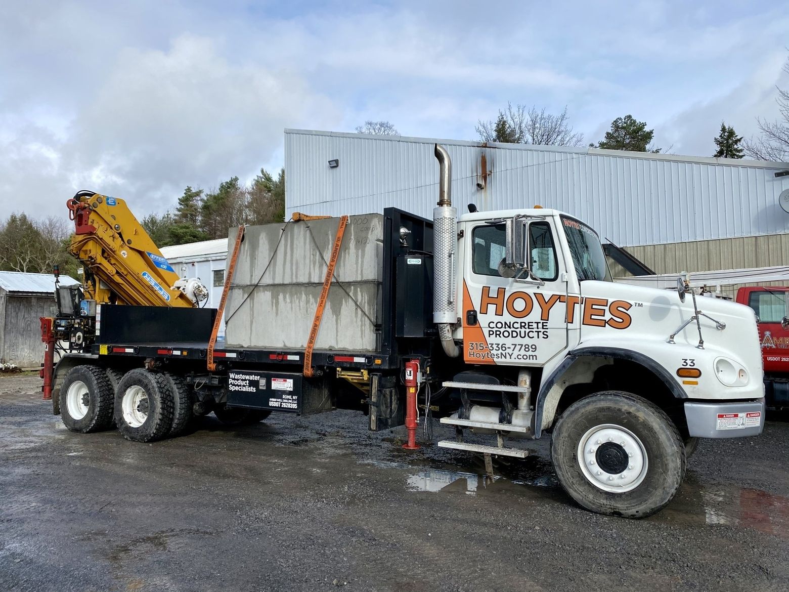 a hoytes truck is parked in a parking lot next to a building .