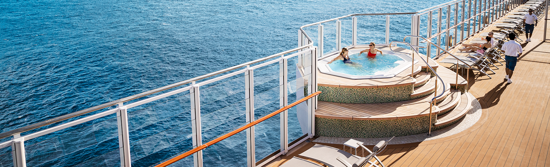 A man and a woman are walking on the deck of a cruise ship.