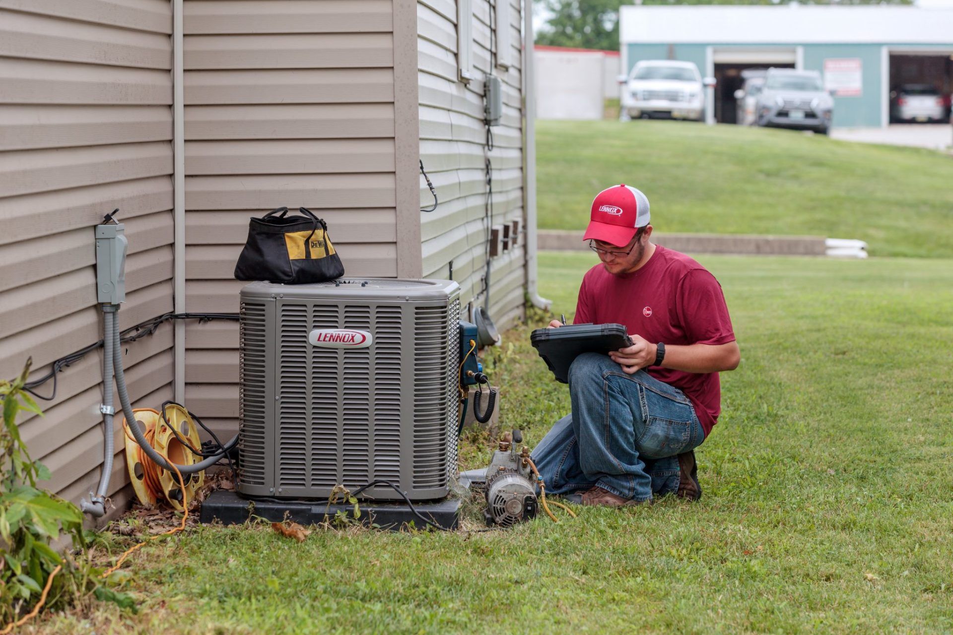 An HVAC Professional From Controlled Aire Taking Notes Outside of a Mid-Missouri Home by an AC Unit.