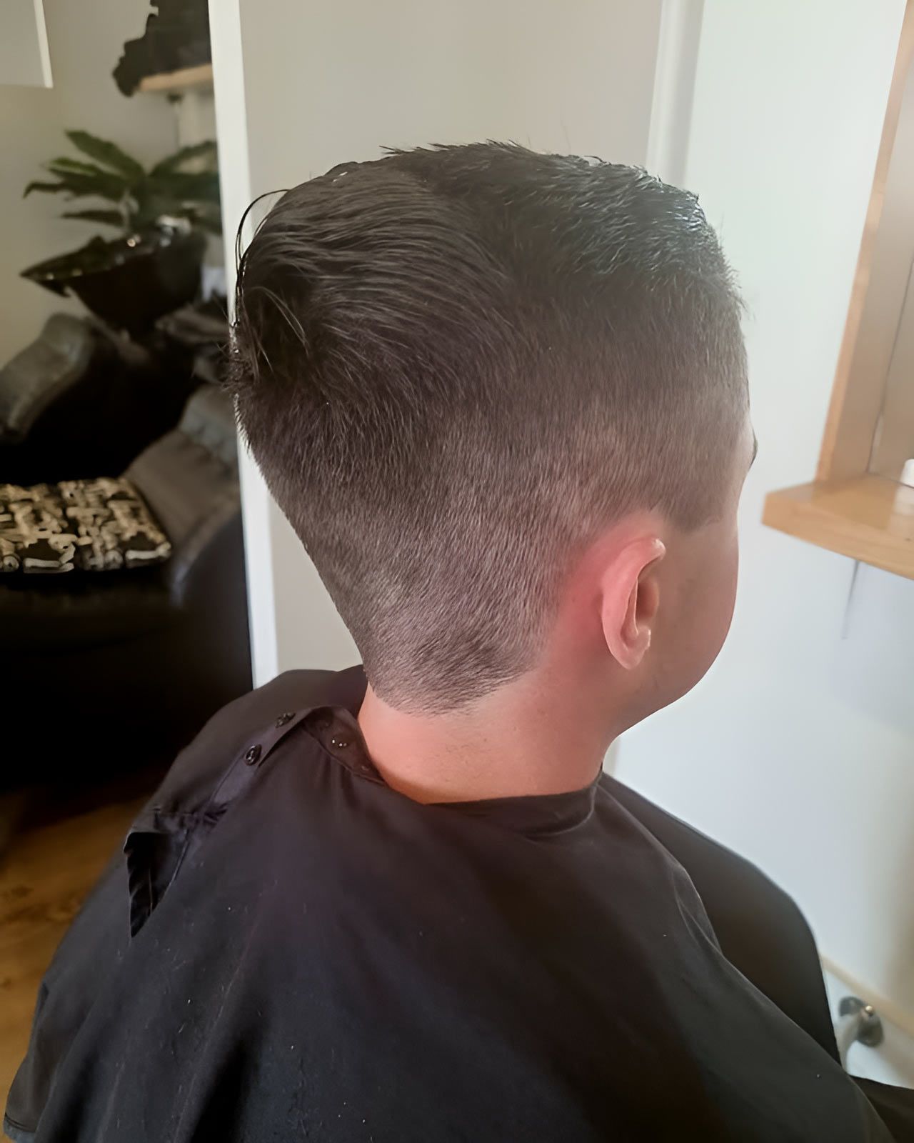 A Kid's In A Black Cape Is Getting His Hair Cut — Arabella Hair Design in Sebastopol, VIC