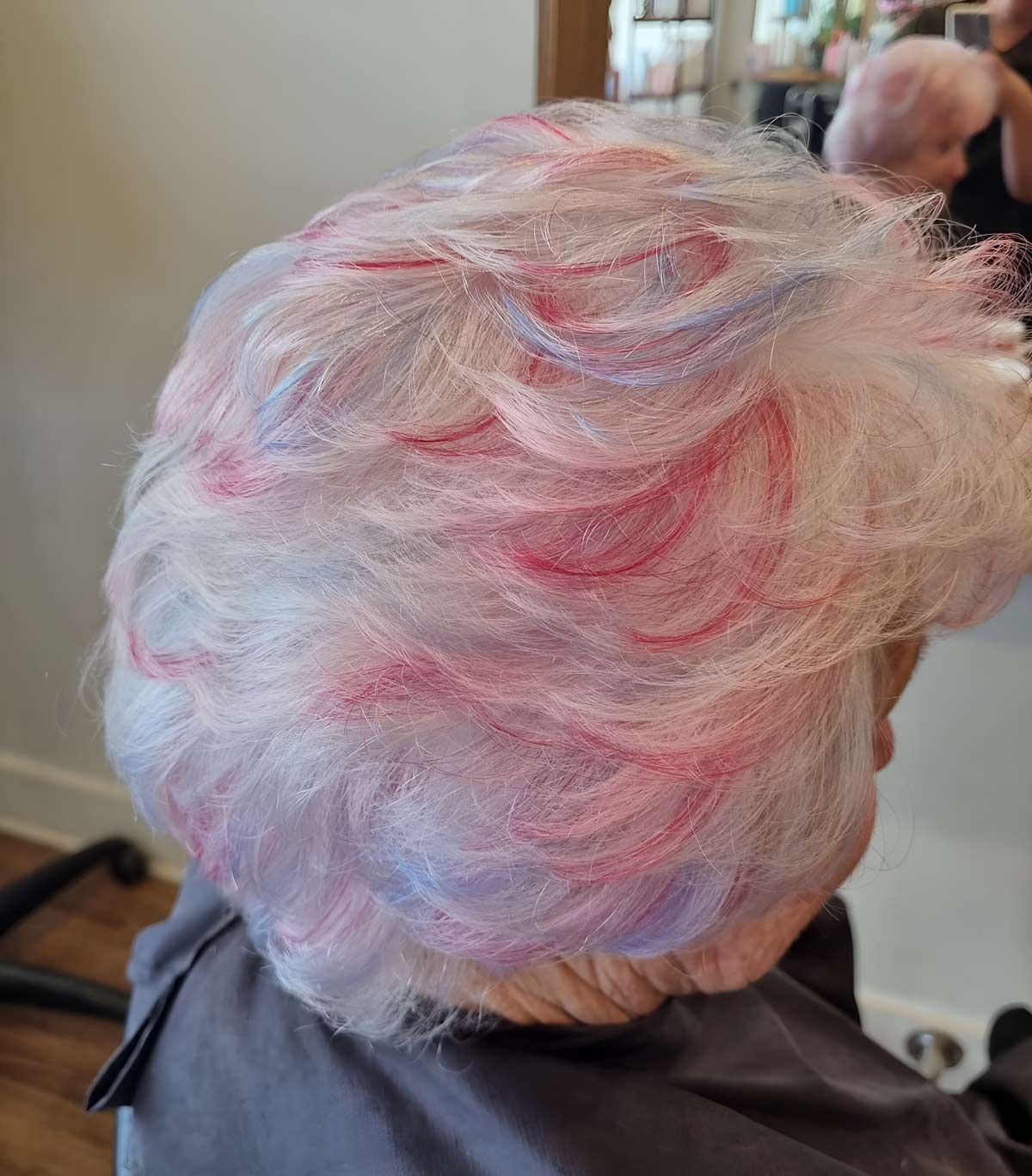 A Senior Woman With Pink And Purple Hair Is Getting Her Hair Dyed In A Salon — Arabella Hair Design in Sebastopol, VIC