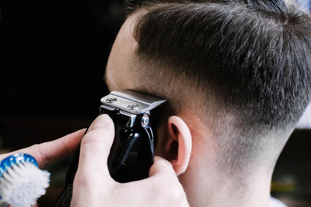 A Man Is Getting His Hair Cut With A Clipper — Arabella Hair Design in Sebastopol, VIC
