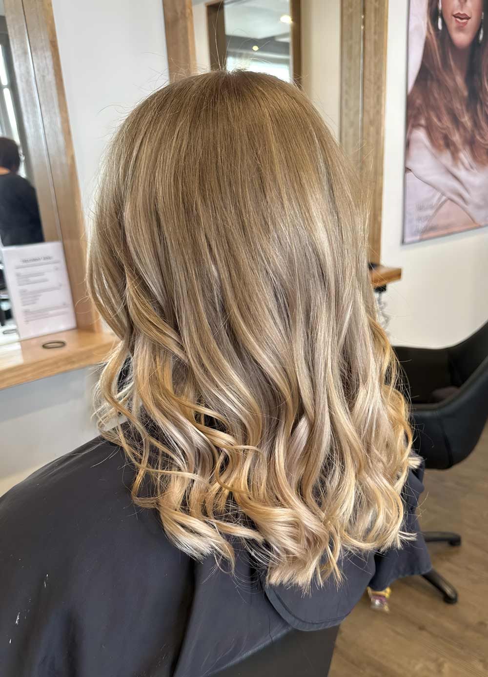 A Woman With Blonde Hair Is Sitting In A Chair In A Salon — Arabella Hair Design in Sebastopol, VIC