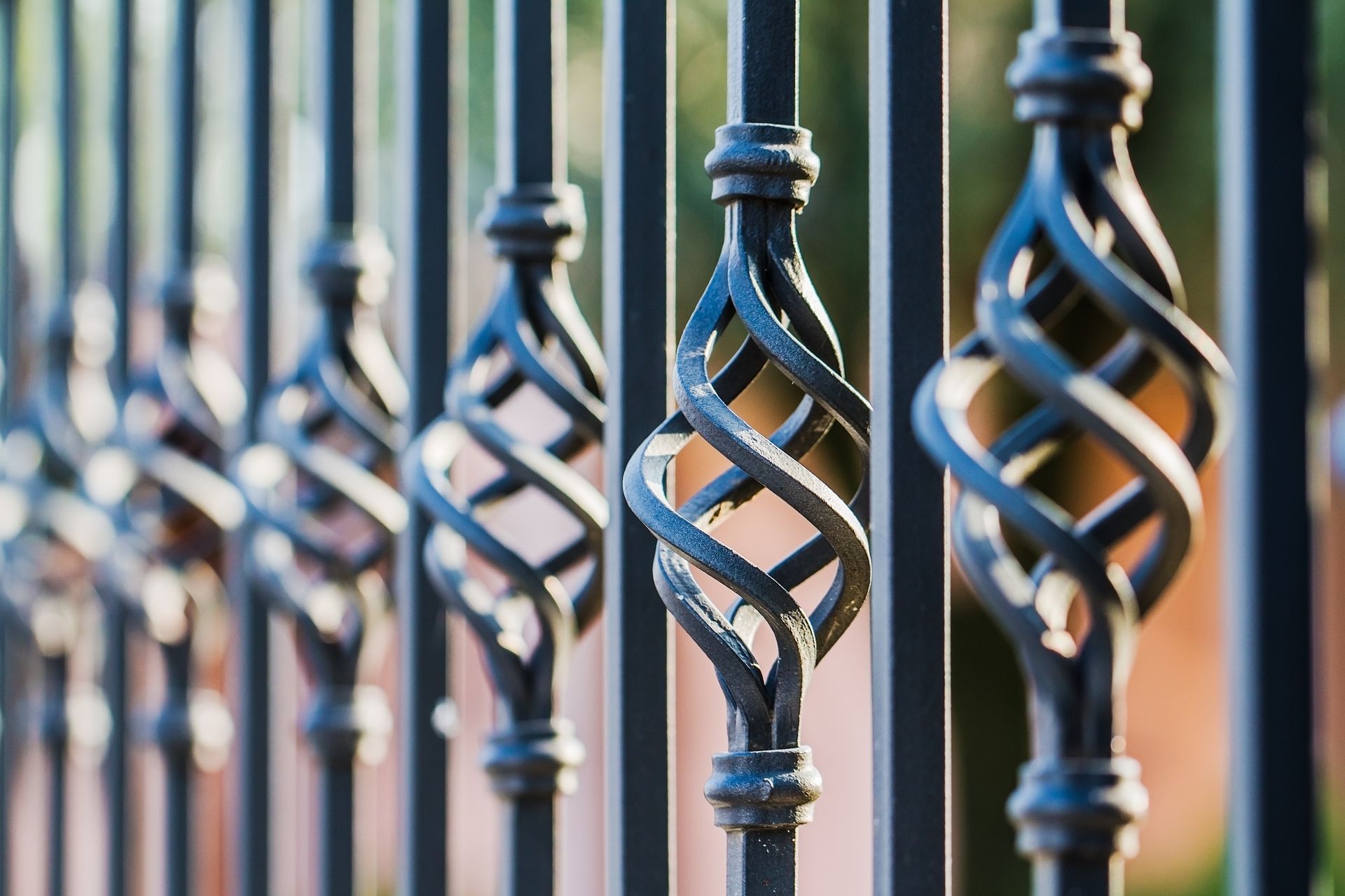 A close up of a wrought iron fence with a twisted design.