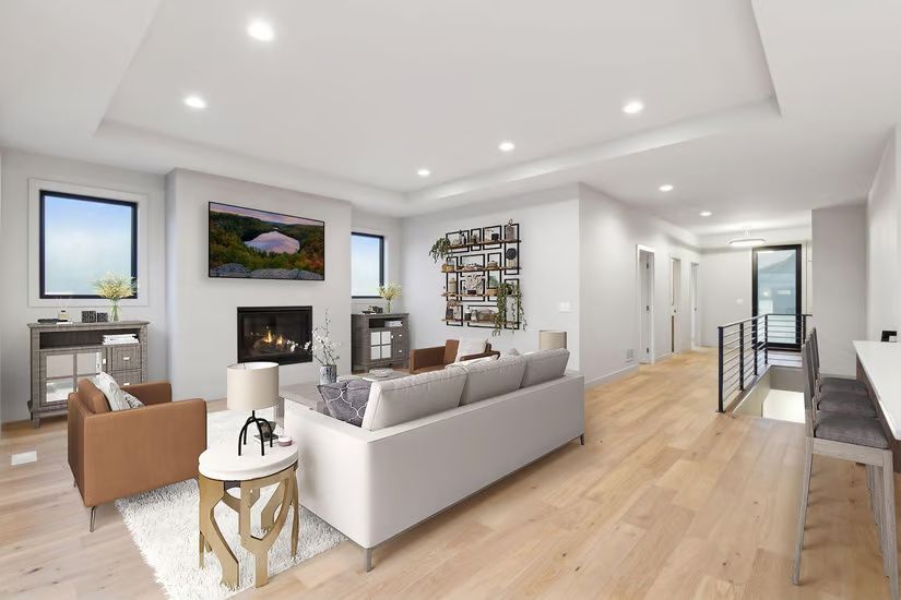 Modern living room with fireplace, TV, light wood floors, and neutral-colored furniture.
