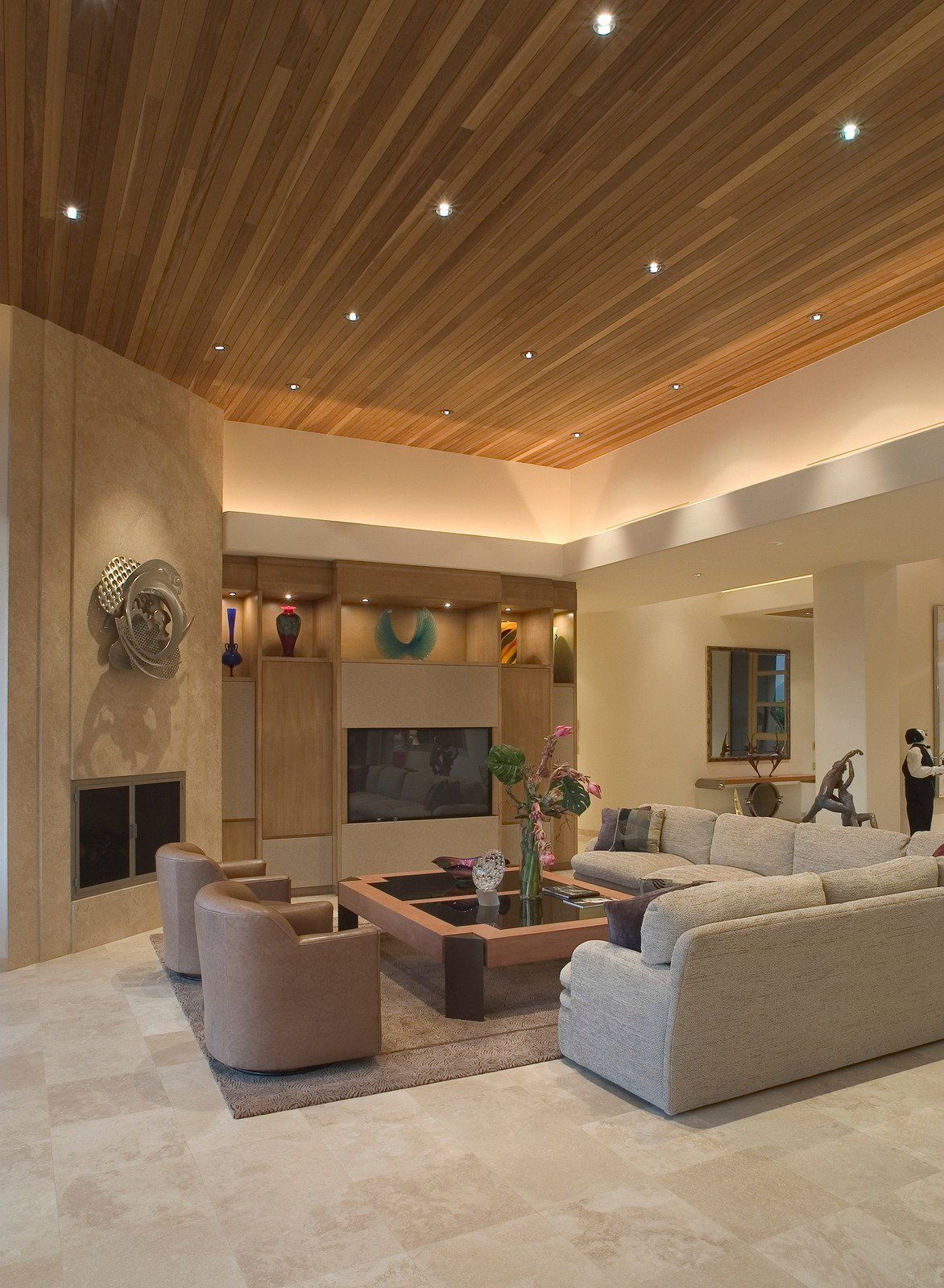 Living room with wood ceiling, neutral tones, fireplace, and modern furniture.