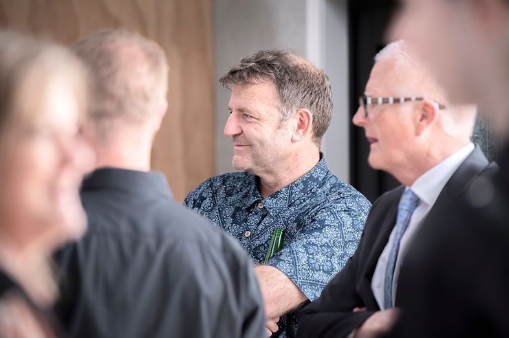 Man in Blue Shirt and Black Tie Conversing with Others | Upper Hutt, NZ | Hui Kitchens