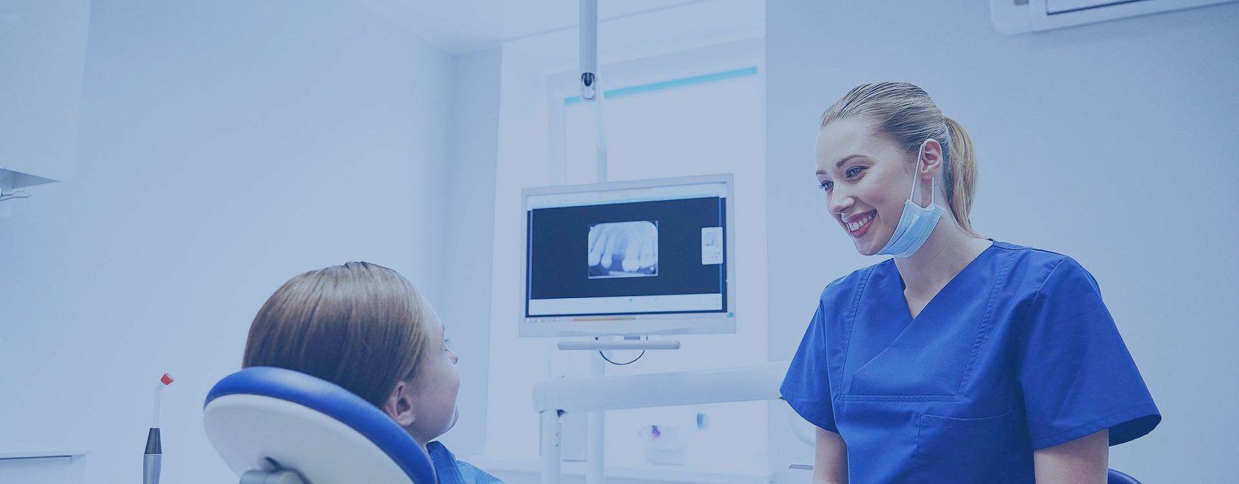 a female dentist is talking to a patient in a dental chair .