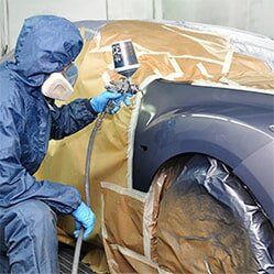 SUV Repair — Man Spraying Paint on Car in Hayward, CA