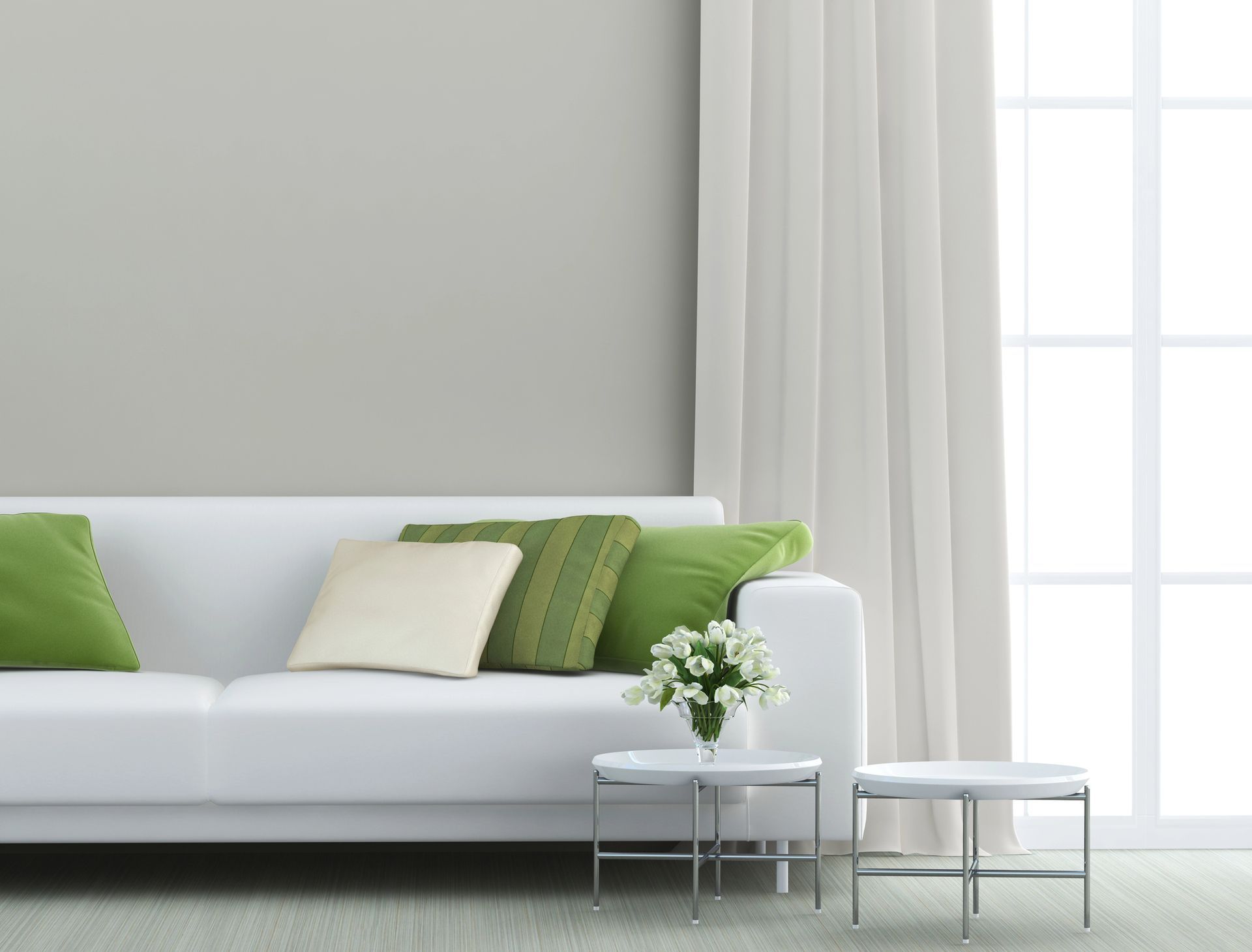 A living room with a white couch and green pillows