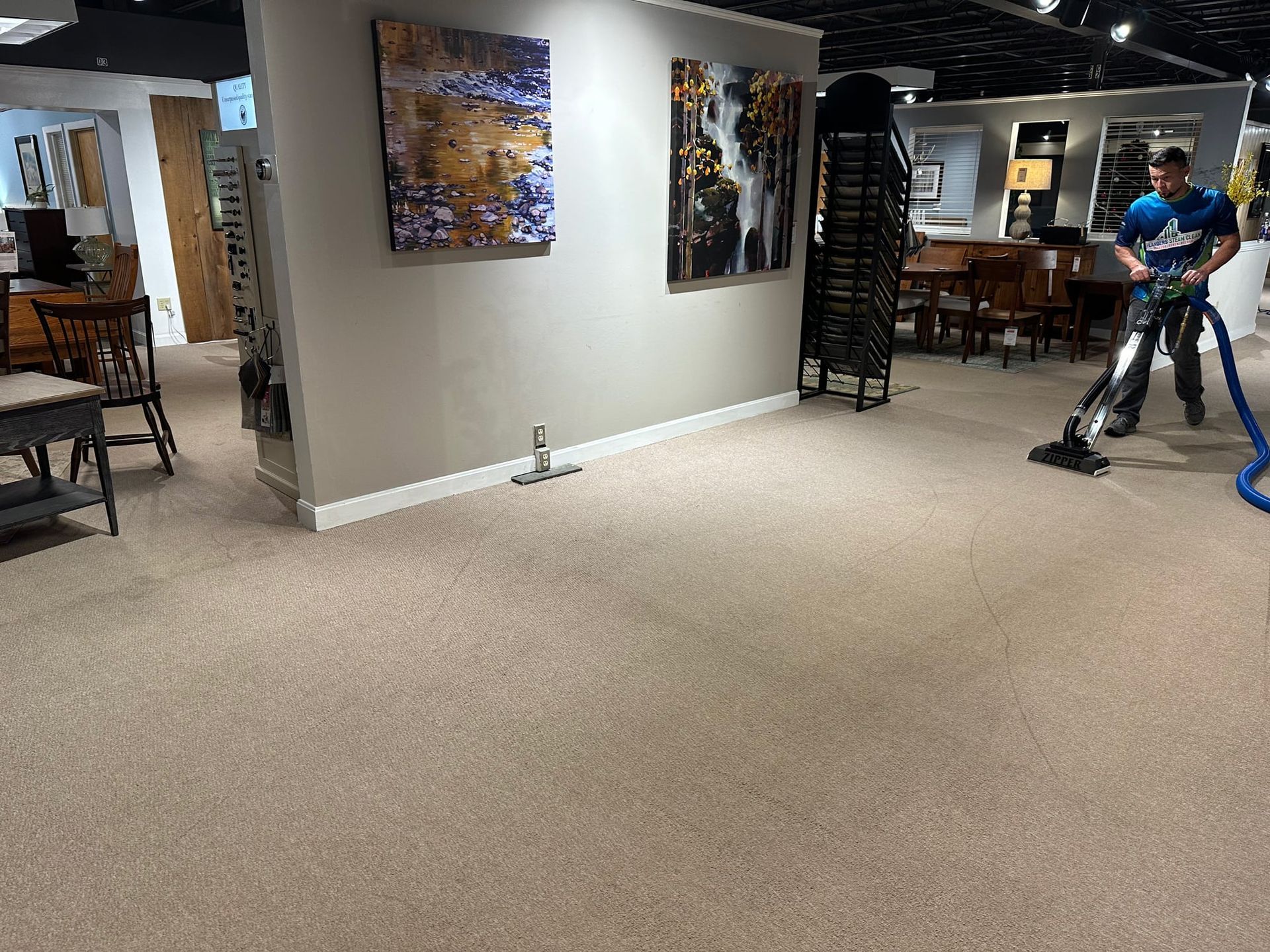 A man is using a vacuum cleaner to clean a carpet in a room.