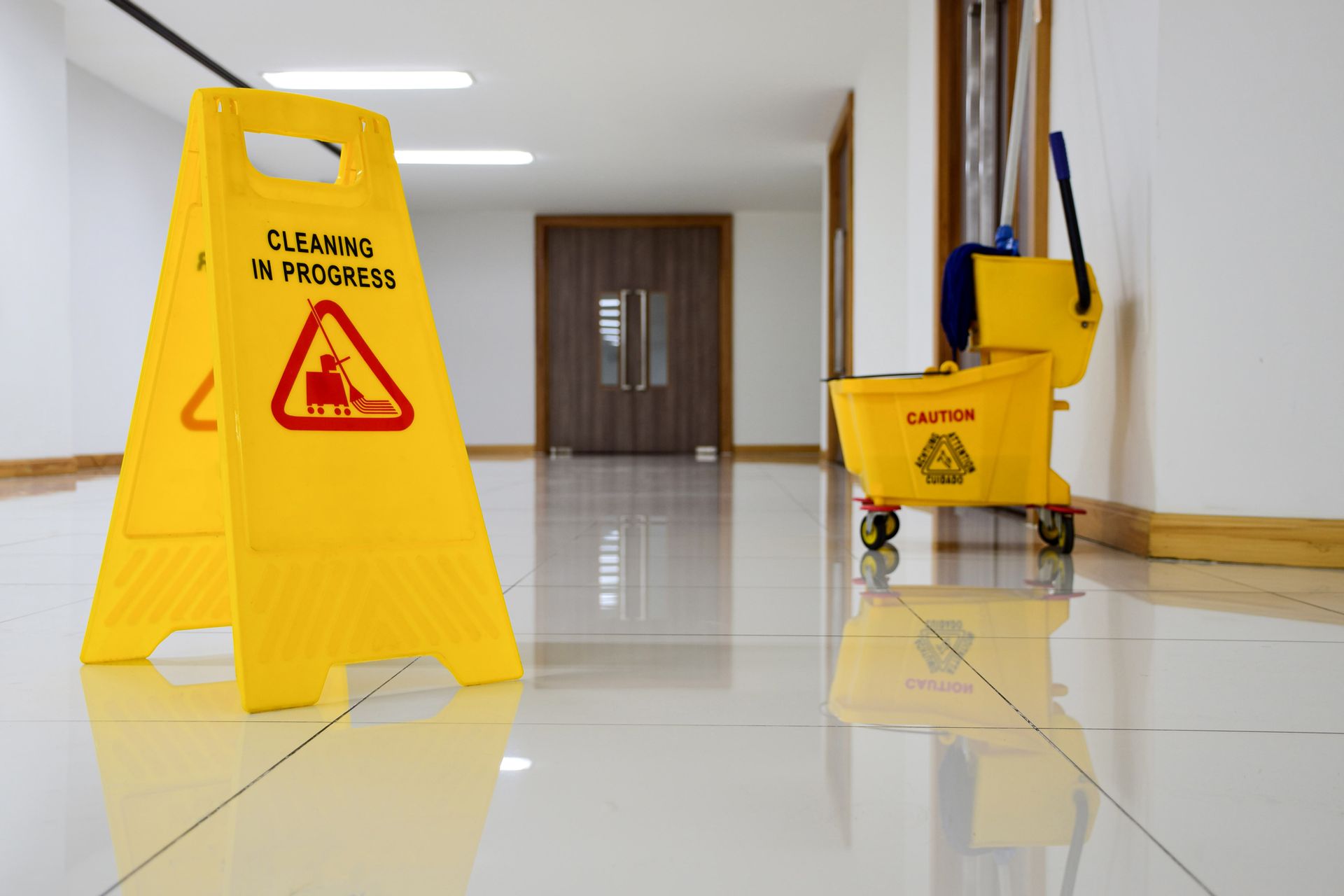 A yellow caution sign is on the floor next to a mop bucket.