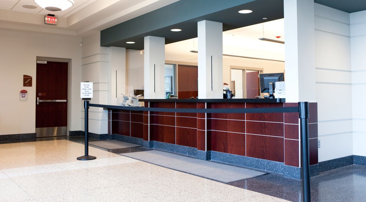 A lobby with a wooden counter and a black barrier
