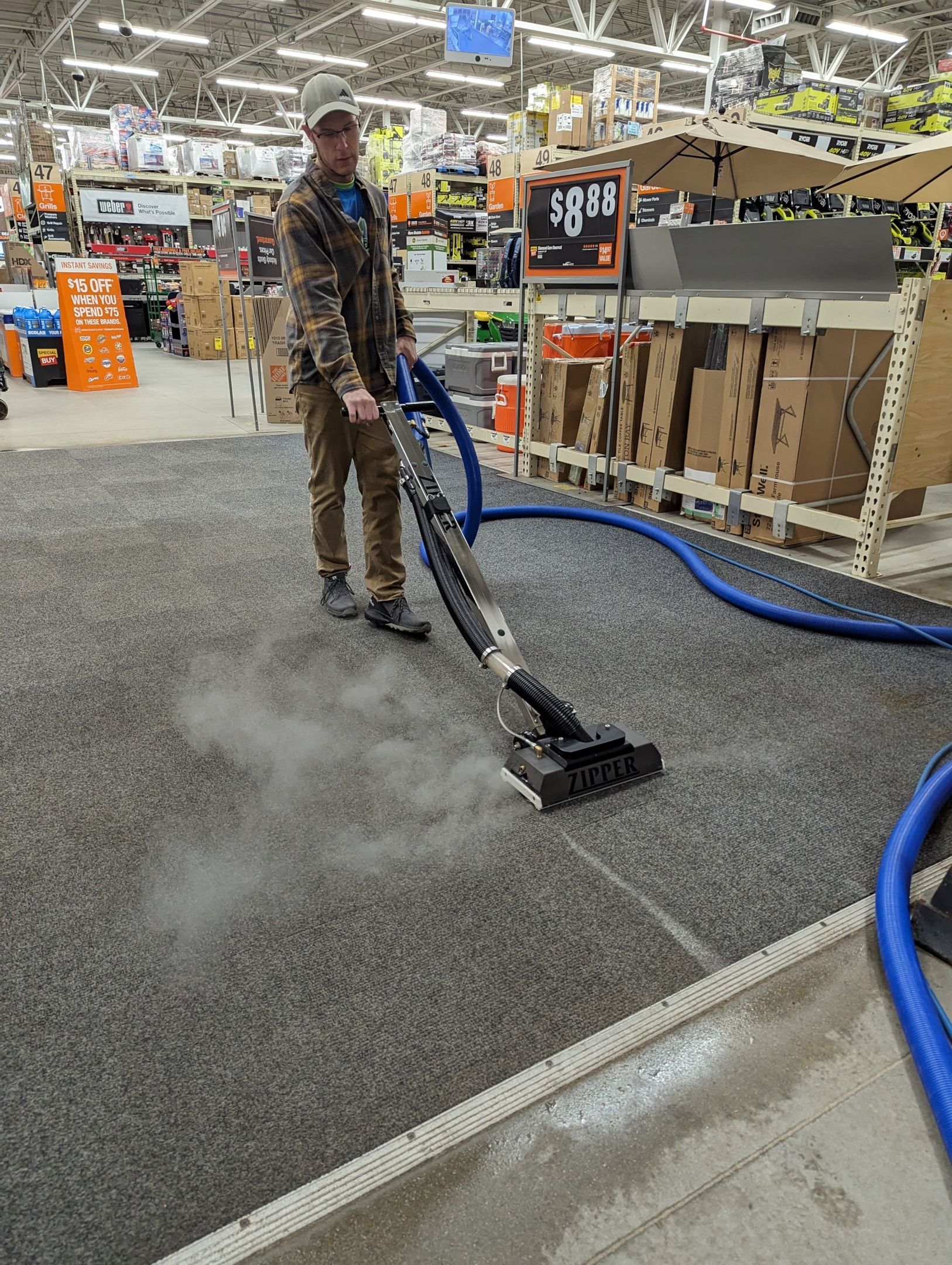 A man is using a vacuum cleaner to clean the floor of a store.