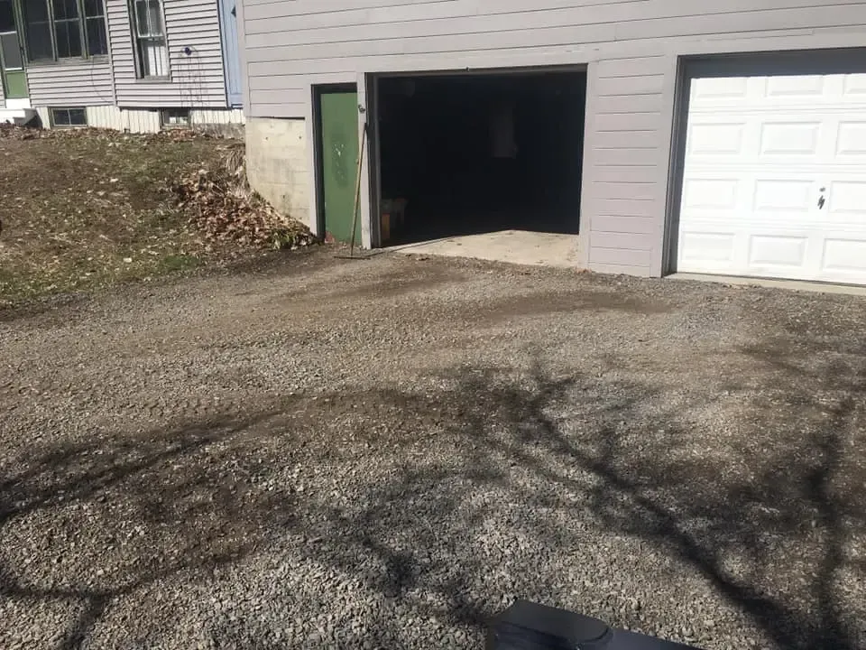 A garage door is open in front of a house.
