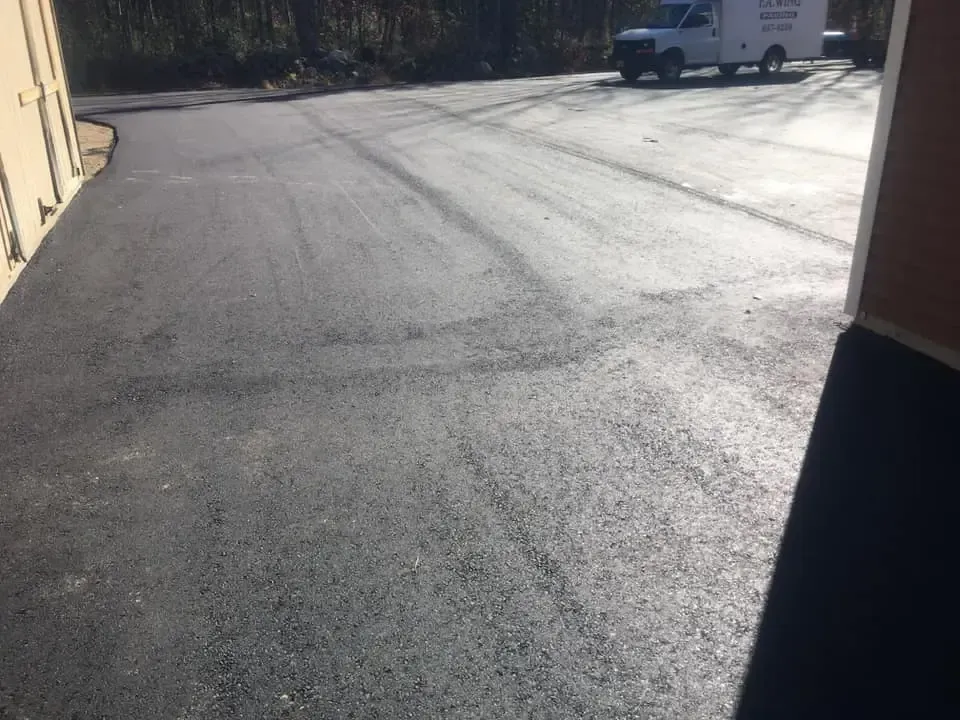 A white van is parked in a parking lot next to a building