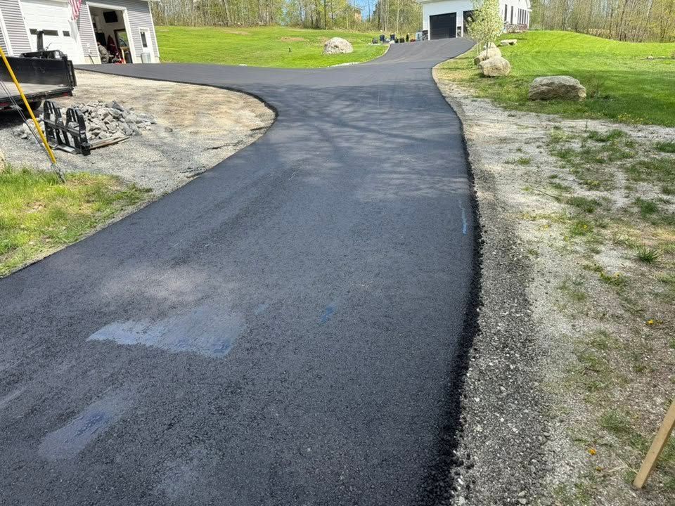 A newly paved driveway with a truck parked on the side of it.