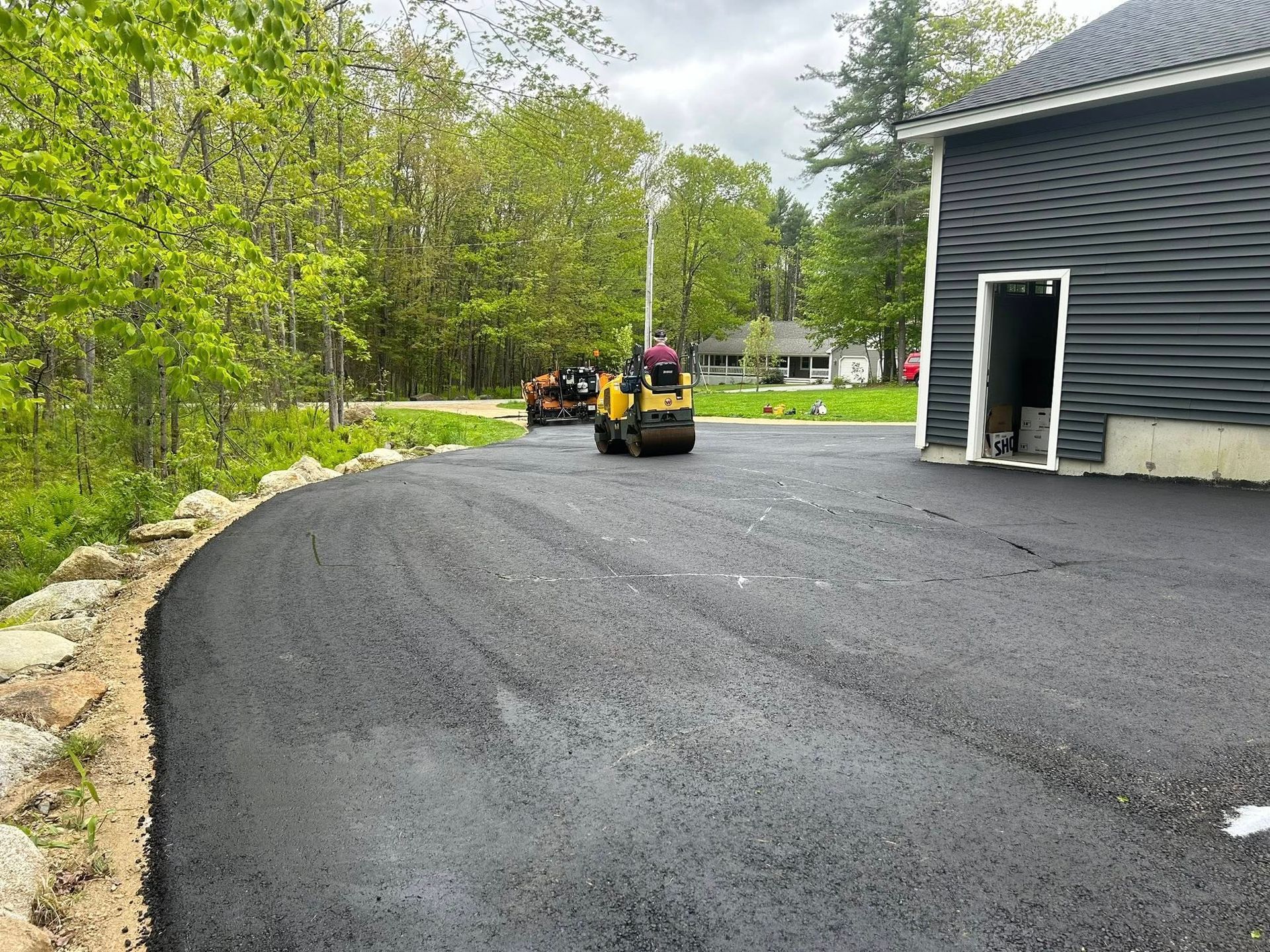 A driveway is being paved in front of a house