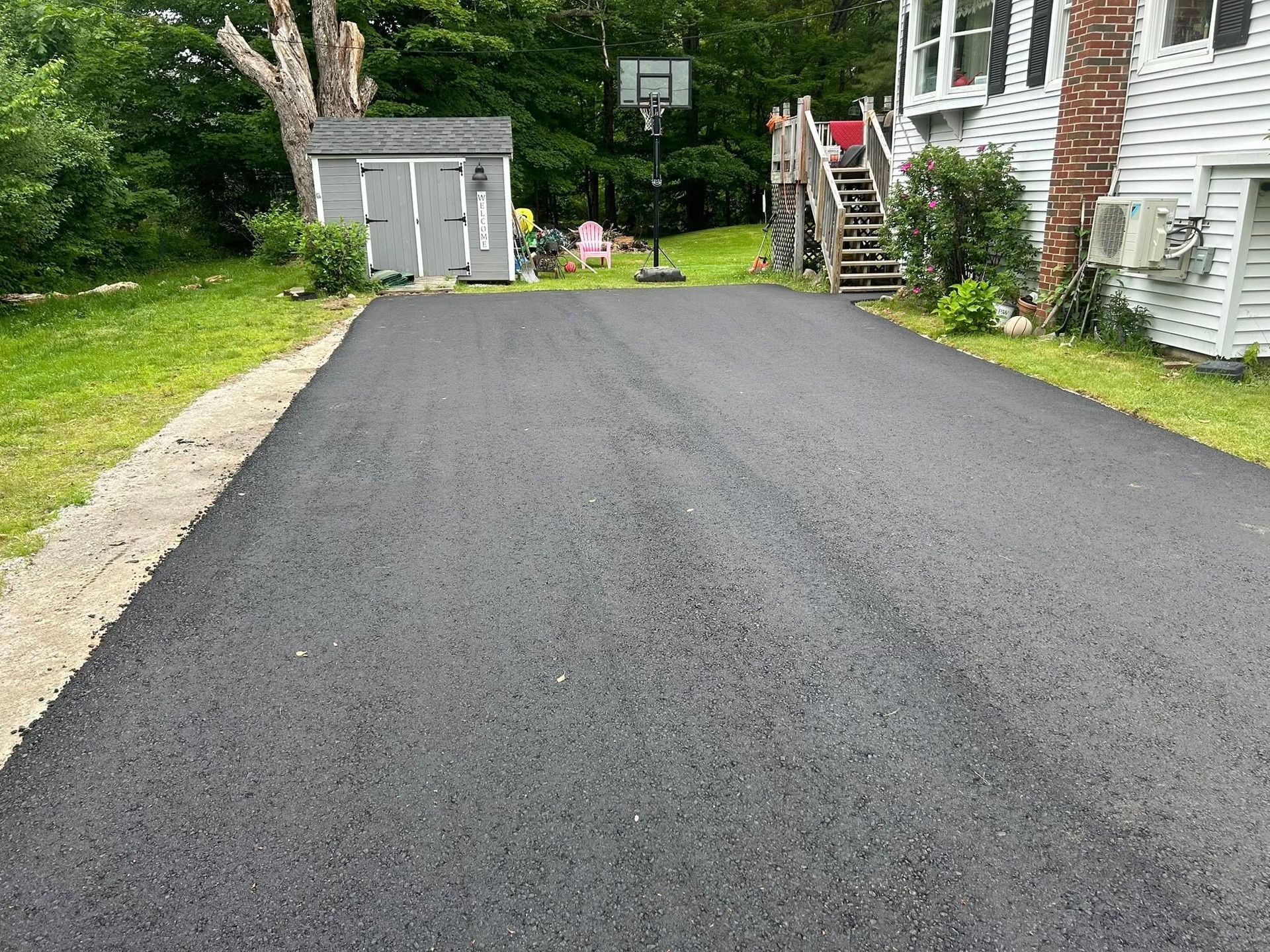 There is a basketball hoop in the middle of the driveway.