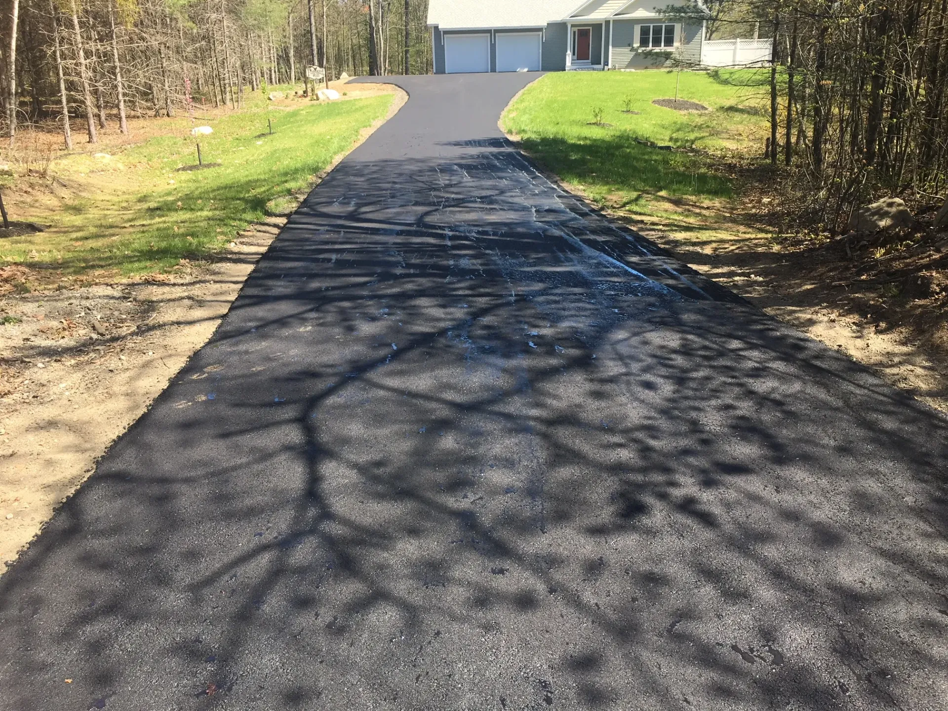 A driveway leading to a house in the woods
