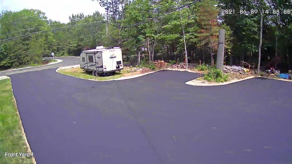 A rv is parked in a parking lot next to a road.