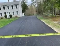 A black road with a yellow caution tape along the side of it.