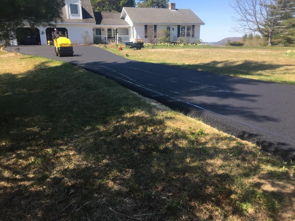 A yellow lawn mower is cutting grass in front of a house.