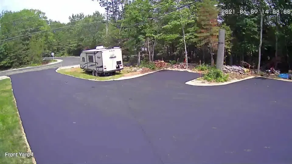 A rv is parked in a parking lot next to a road.