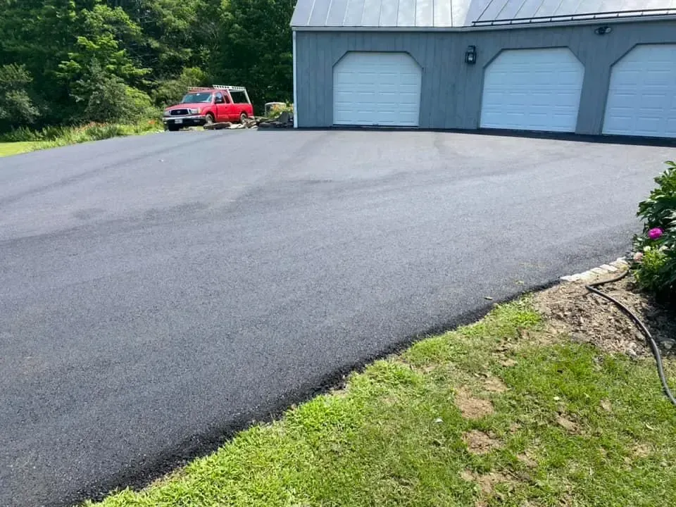 A red truck is parked in a driveway in front of a garage