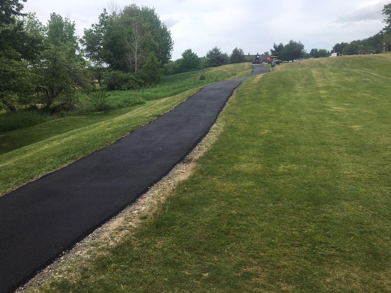 A road that is going through a grassy field.